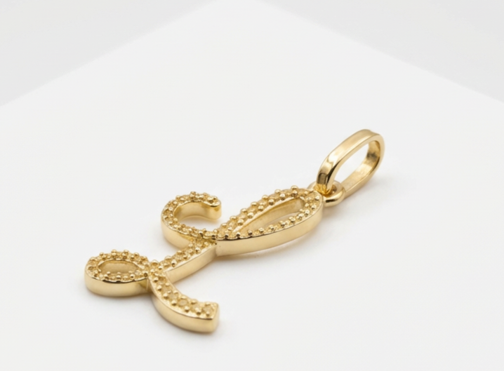 Gold infinity symbol pendant on a white background