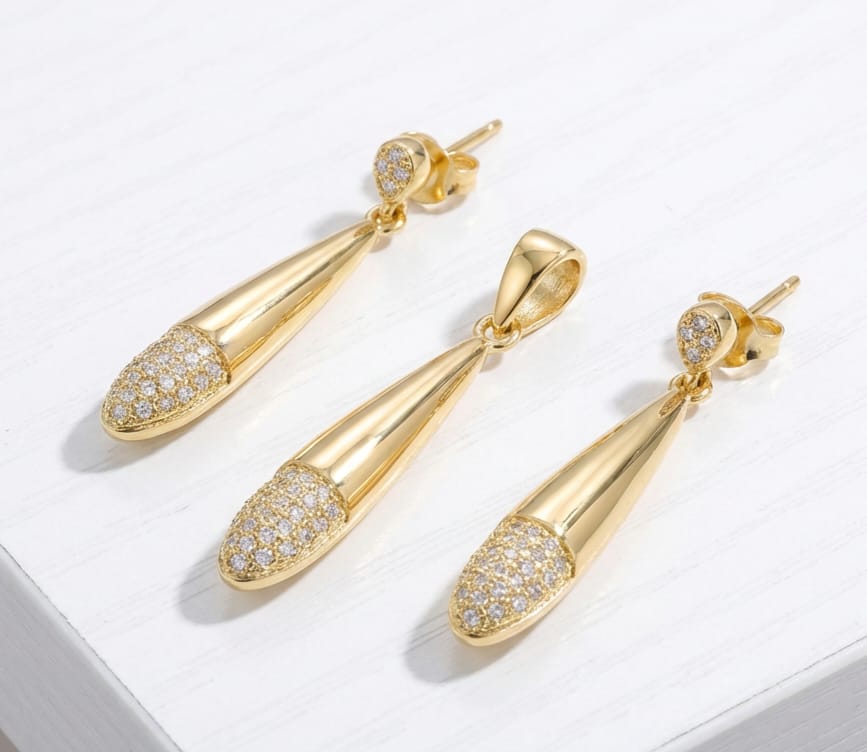 Gold teardrop earrings with fancy stones on a white background