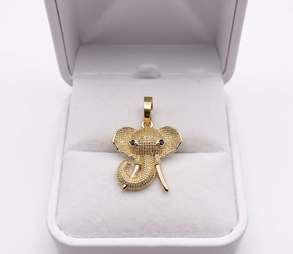 Gold elephant pendant in a white jewelry box
