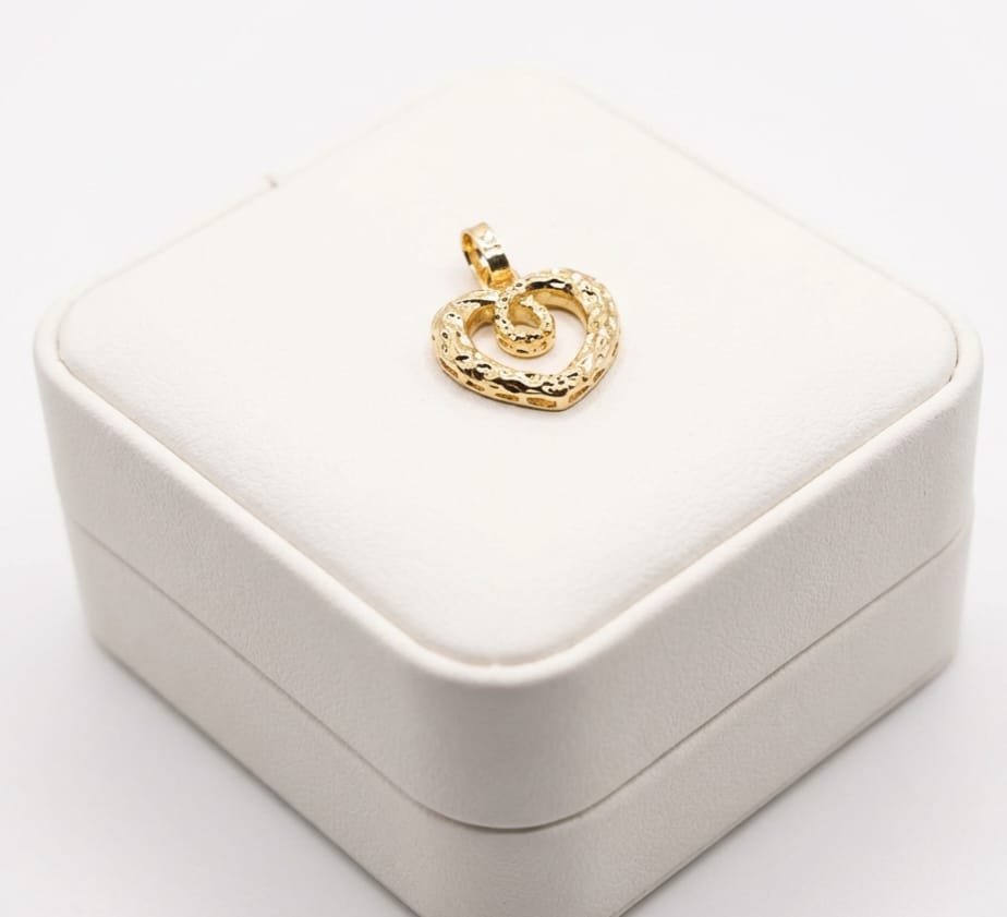 Gold heart-shaped pendant on a white jewelry box
