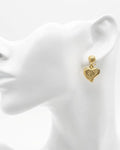Gold heart-shaped earring on a white mannequin head