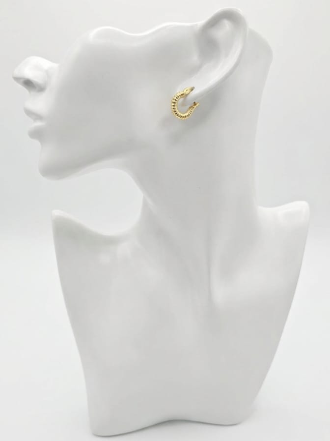 Gold hoop earring on a white mannequin bust