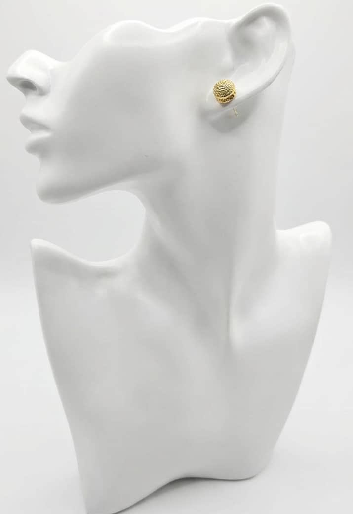 Gold earrings on a white mannequin bust