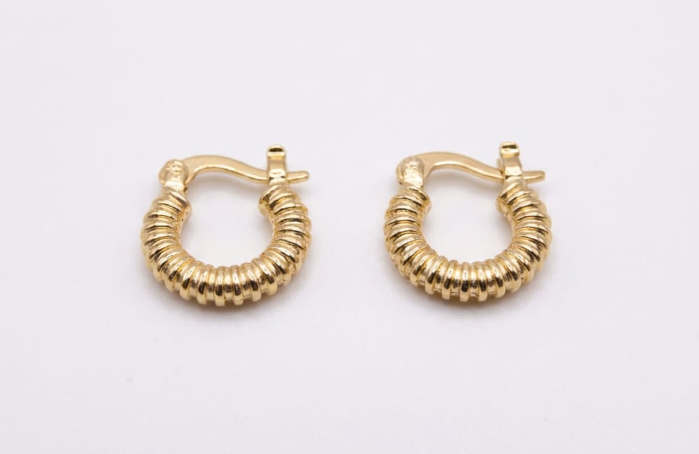 Pair of gold hoop earrings on a light gray background