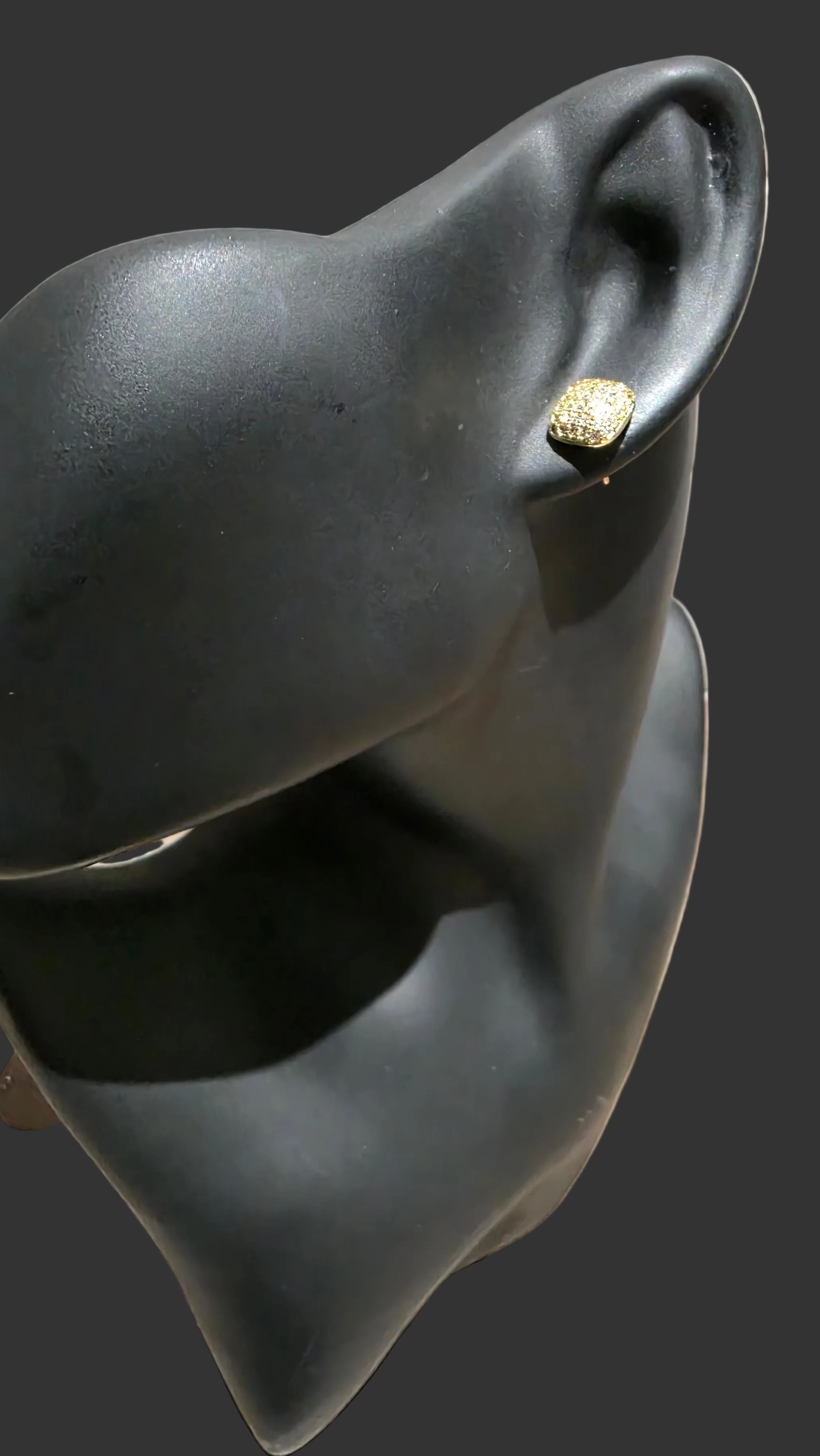 Black mannequin with a gold-plated stud.